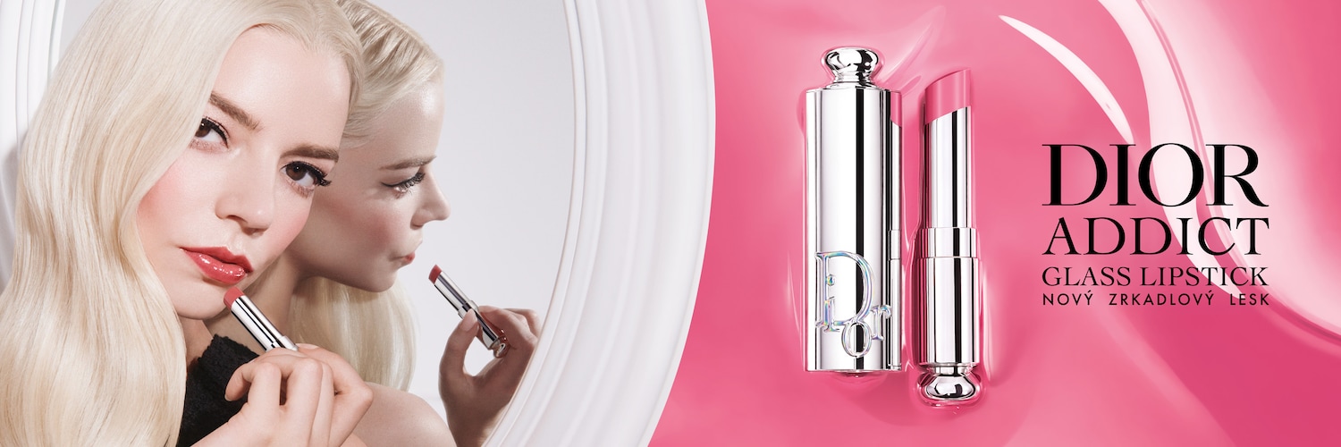 Na obrázku je blondínka s lesklým ružovým rúžom Dior Addict Glass Lipstick, ktorý si nanáša pred zrkadlom, pričom v pozadí je zobrazený rúž v striebornom obale a ružové pozadie.