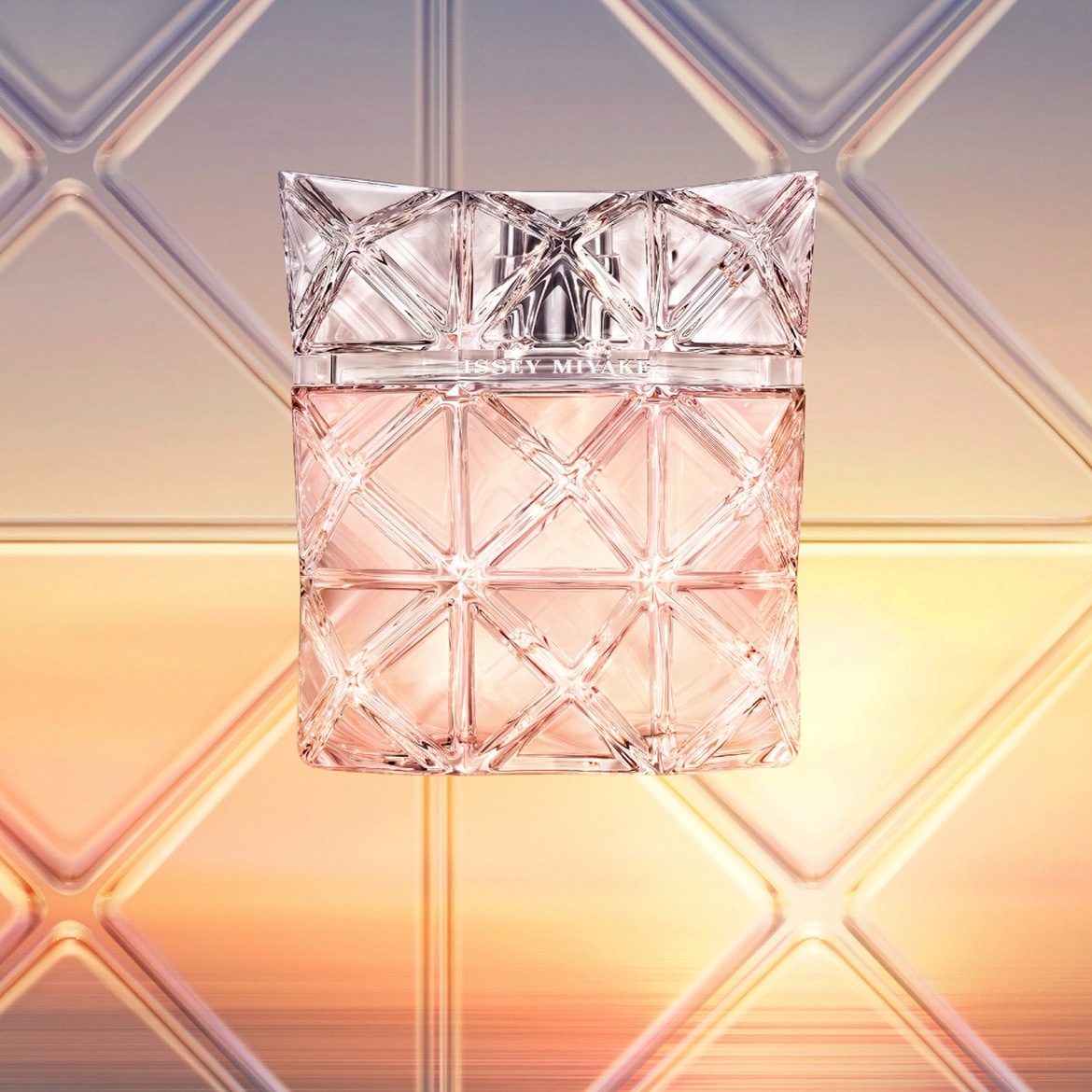 Priehľadný sklenený flakón parfému Issey Miyake s geometrickým dizajnom a ružovým nádychom.