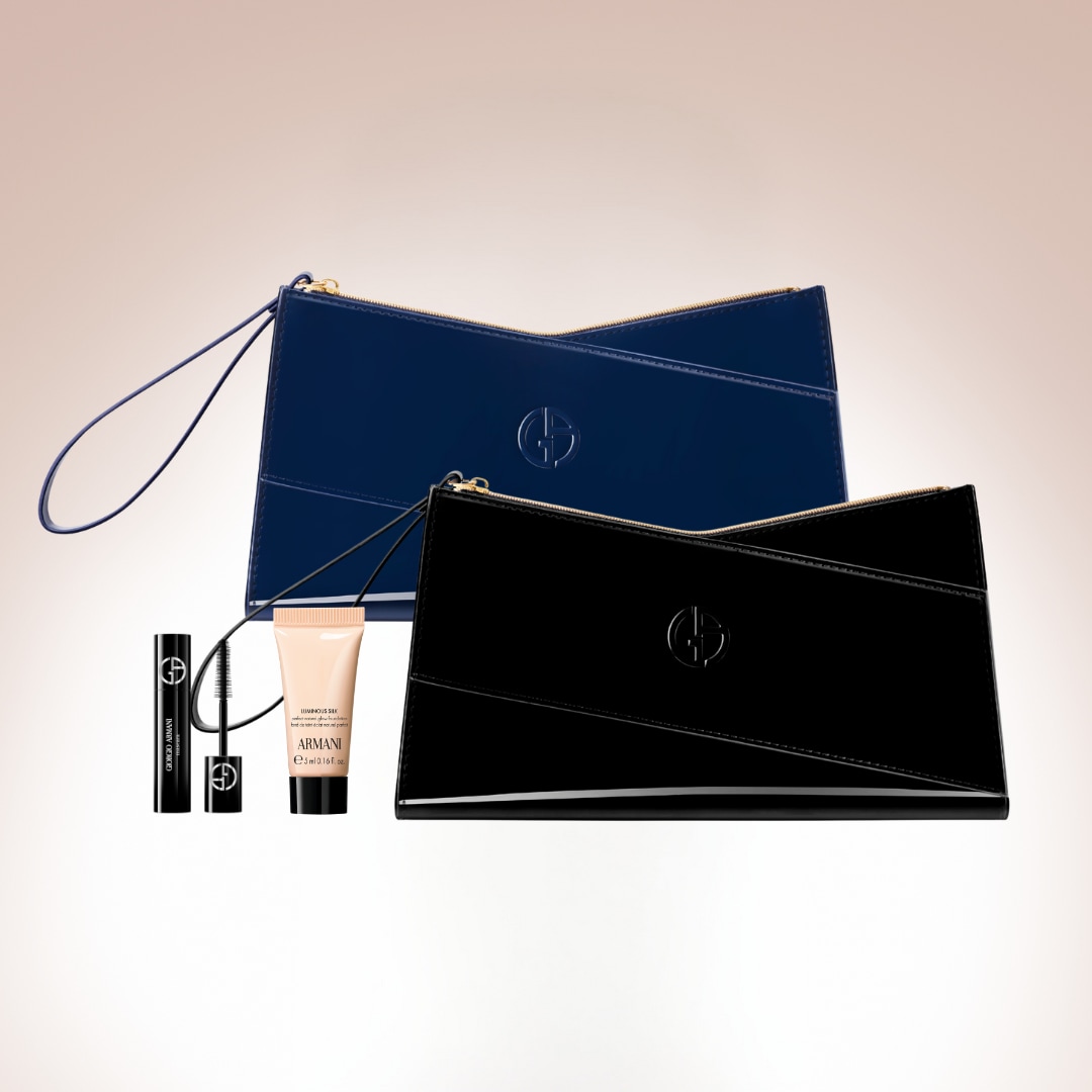 Dve lesklé kozmetické taštičky Giorgio Armani, jedna tmavomodrá a druhá čierna, s maskarou a podkladovou bázou, ideálne na usporiadanie vašich základných produktov.