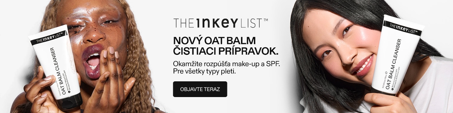 Žena s kučeravými vlasmi drží v ruke biely tubový čistiaci prípravok The Inkey List Oat Balm Cleanser, ktorý odstraňuje make-up a SPF.